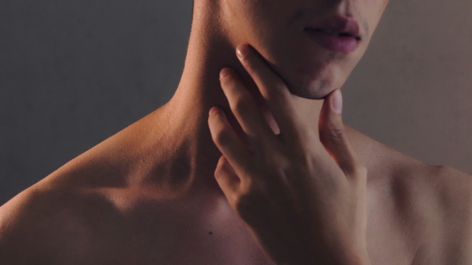 A person gently touching the glands at the side of the neck